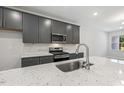 Beautiful kitchen features a speckled white countertop, stainless steel appliances, and modern gray cabinetry at 484 Traditions Grande Blvd # 29, Wake Forest, NC 27587