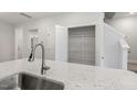 Kitchen island with a deep sink, granite countertop, and pantry door, with access to the upper level at 484 Traditions Grande Blvd # 29, Wake Forest, NC 27587