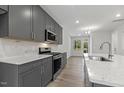 Spacious kitchen with granite countertops, modern appliances, gray cabinets, and an open view to the dining area at 484 Traditions Grande Blvd # 29, Wake Forest, NC 27587