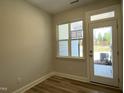 Bright room featuring a large window, door, and wood-look flooring, offering a modern, clean aesthetic at 484 Traditions Grande Blvd # 29, Wake Forest, NC 27587