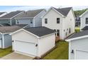 View of the home's rear exterior and detached garage, showcasing the backyard and patio at 9237 Kitchin Farms Way # 429, Wake Forest, NC 27587