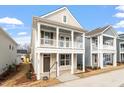 Stylish two-story house showcasing a double stacked porch, neutral siding, and white railings at 9237 Kitchin Farms Way # 429, Wake Forest, NC 27587