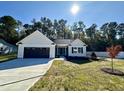 Beautiful single-story home with a well-maintained lawn, a black garage door, and mature trees at 207 Earnest Way # 15, Kenly, NC 27542