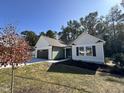 Well-manicured single-story home with green siding, a dark garage door, and lush landscaping at 207 Earnest Way # 15, Kenly, NC 27542