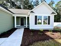 Inviting front entrance of a home featuring a dark door, white columns, and fresh landscaping at 207 Earnest Way # 15, Kenly, NC 27542