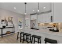 Bright kitchen with white cabinets, quartz countertops, stainless steel appliances, and island with seating at 2401 E Main St, Durham, NC 27703