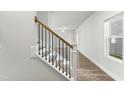 Elegant staircase featuring hardwood steps, white risers, and wrought iron balusters at 733 Portland Rose Dr, Knightdale, NC 27545