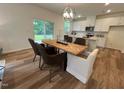 Open dining area with a herringbone-patterned table, pendant lighting, and ample seating at 19 Longdale Dr, Graham, NC 27253