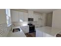 Bright kitchen features white cabinets, modern appliances, stone countertops, and hardwood style floors at 19 Longdale Dr, Graham, NC 27253
