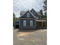 Stunning new construction featuring a blue exterior, stone accents, and an attached two car garage at 911 Golfers Vw, Pittsboro, NC 27312