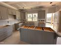 Bright kitchen featuring shaker style gray cabinets, kitchen island, and an exterior access door at 182 Wilderness Trl, Smithfield, NC 27577