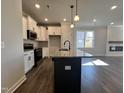 Kitchen features an island with granite countertops, stainless steel appliances, and a sink at 20 S Mistflower St, Clayton, NC 27520