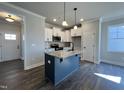 Modern kitchen with granite island, stainless steel appliances and hardwood flooring at 20 S Mistflower St, Clayton, NC 27520