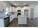Bright kitchen boasts white cabinetry, stainless steel appliances, granite countertops, and a convenient center island at 232 Bluejay St, Clayton, NC 27520