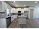 Modern kitchen featuring white cabinetry, stainless steel appliances, granite countertops, and a center island at 35 S Mistflower St, Clayton, NC 27520
