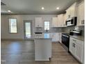Bright kitchen with granite counters, an island, stainless appliances, and an adjacent dining area at 35 S Mistflower St, Clayton, NC 27520