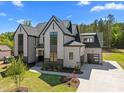 Stunning exterior view of modern two-story home featuring black-framed windows, a garage and a beautiful lawn at 65 Cherry Bark Dr, Youngsville, NC 27596