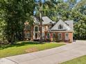 Charming brick two-story home with a long driveway and well-manicured front lawn at 111 N Coslett Ct, Cary, NC 27513