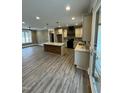 Open concept kitchen with an island, modern cabinetry, stylish pendant lights, and wood flooring at 2829 Faucette Ln, Burlington, NC 27217