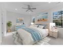 Comfortable bedroom with large windows, soft carpet, coastal artwork, and a ceiling fan at 100 Carol Cir, Louisburg, NC 27549