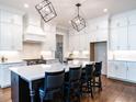 Spacious kitchen with a large island and seating, custom cabinets, stainless steel appliances, and hardwood floors at 123 Cottage Way, Pittsboro, NC 27312