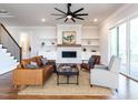 Bright living room featuring a ceiling fan, fireplace, and neutral colored furniture and decor at 123 Cottage Way, Pittsboro, NC 27312