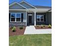 Charming exterior view showcases stone accents, black shutters, well-maintained landscaping, and a welcoming walkway at 28 Decatur Dr, Fuquay Varina, NC 27526