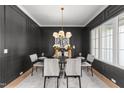 Elegant dining room with dark paneled walls, a modern chandelier, and seating for six at 30 Spanish Oak Dr, Youngsville, NC 27596