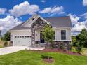 Charming home featuring a stone archway, two-car garage, and a well-manicured lawn at 85 Claude Creek Way, Smithfield, NC 27577