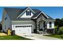 A charming home featuring stone accents, white siding, and a convenient two-car garage at 85 Claude Creek Way, Smithfield, NC 27577