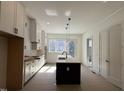 Open kitchen design with a central island, modern lighting and sleek appliances at 704 Chatham View Rd # 12, Cary, NC 27511