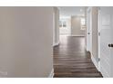 Hallway features elegant hard wood flooring and neutral walls leading to a sunny room at the back at 1125 Brookfield Dr, Gibsonville, NC 27249