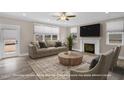 Bright living room featuring a fireplace, large windows, and a comfortable seating arrangement at 1129 Brookfield Dr, Gibsonville, NC 27249