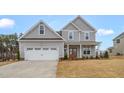 Charming two-story home with a two car garage, covered porch, and manicured lawn at 1129 Brookfield Dr, Gibsonville, NC 27249