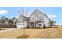 Charming two-story home with a two car garage, covered porch, and manicured lawn at 1129 Brookfield Dr, Gibsonville, NC 27249