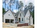 An exterior view of a two-story home showing an attached garage and a yard with trees at 3325 Colby Chase Dr # 9, Apex, NC 27539