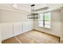 Unfinished dining room features a large window, modern light fixture, and classic wall trim at 2613 Silver Gate Ct, Wake Forest, NC 27587
