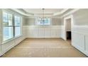 Bright dining room with wainscoting, chandelier and large windows at 2617 Silver Gate Ct, Wake Forest, NC 27587