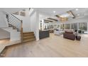 Bright, open-concept living room with hardwood floors, beamed ceilings, and access to the outdoor area at 7640 Falls Creek Ln, Raleigh, NC 27614