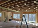Unfinished living room featuring exposed studs, ample natural light, and sliding glass doors to the backyard at 3331 Colby Chase Dr # 8, Apex, NC 27539