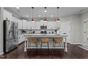 Spacious kitchen boasting a large island with seating, modern lighting fixtures, and stainless steel appliances for easy meals at 609 Meadowgrass Ln, Wake Forest, NC 27587