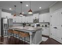 Bright kitchen featuring a large center island with stylish seating, stainless steel appliances, and abundant white cabinetry at 609 Meadowgrass Ln, Wake Forest, NC 27587