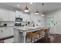 Well-equipped kitchen with stainless steel appliances, granite countertops, a central island, and stylish pendant lighting at 609 Meadowgrass Ln, Wake Forest, NC 27587