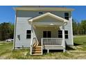 Back exterior of home features a lovely covered deck with white railings, offering a perfect spot for outdoor relaxation at 235 Grand Griffon Way, Lillington, NC 27546