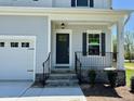 Charming home featuring a welcoming front porch and a stylish dark-colored front door at 235 Grand Griffon Way, Lillington, NC 27546