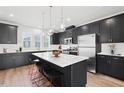 Modern kitchen featuring dark cabinetry, a large island, and stainless steel appliances at 1170 Holding Village Way, Wake Forest, NC 27587