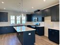 Modern kitchen boasts a stylish island, dark cabinets, stainless appliances, and hardwood flooring at 1170 Holding Village Way, Wake Forest, NC 27587