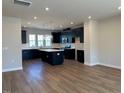 Spacious kitchen with island featuring dark cabinets, hardwood floors and stainless steel appliances at 1170 Holding Village Way, Wake Forest, NC 27587