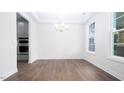 Bright dining room with hardwood floors, white trim, a modern chandelier, and large windows at 1873 Old Fields Blvd, Haw River, NC 27258
