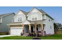Charming two-story home with a well-maintained lawn, a two-car garage, and stone and wood accents at 1873 Old Fields Blvd, Haw River, NC 27258